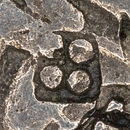 Four dots in a circle, possibly 田 - tián - field, farmland
